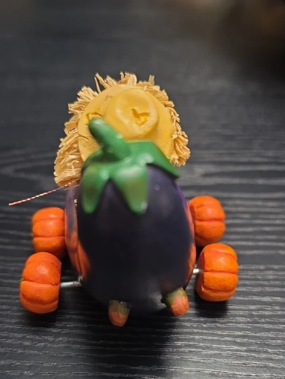 Autumn figurine of a scarecrow in a Eggplant cart